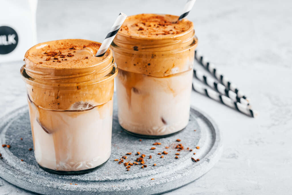 Stylised calorie dense coffee drink. Iced coffee with creamy whipped foam and almond milk. Realting to an article about weight loss and hidden calories