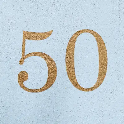 number 50 fifty in gold paint on blue wall.